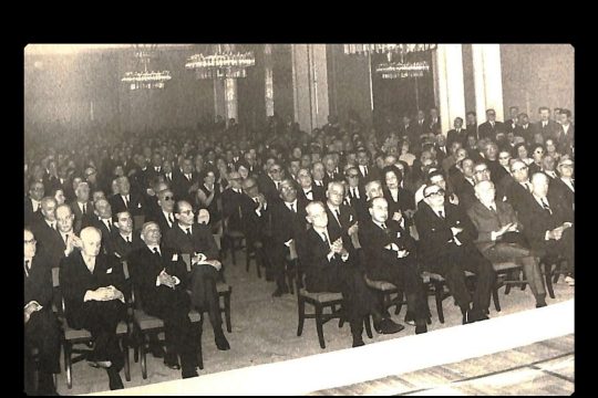 «Χίλτον», Μάρτιος 1966. Τα «σημαίνοντα μέλη της αθηναϊκής κοινωνίας» παρακολουθούν μια από τις διαλέξεις του μελλοντικού «θεωρητικού» της χούντας περί δικτατορίας.
